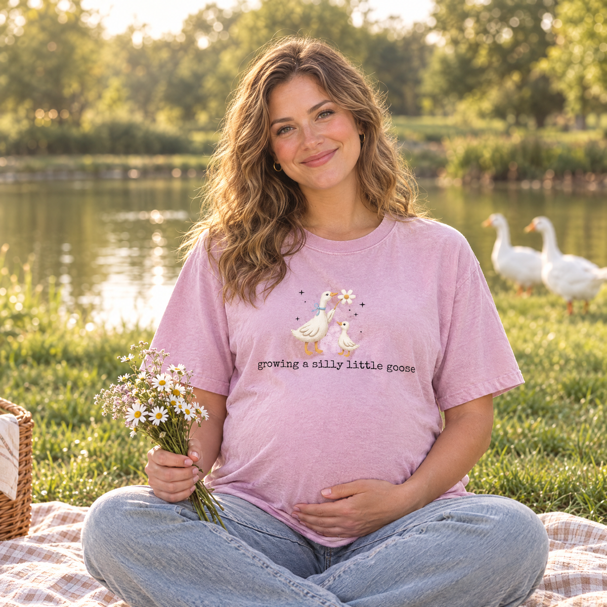 Pregnant woman wearing Blossom Comfort Colors Silly Goose pregnancy shirt at a pond picnic with geese