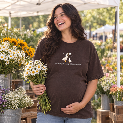 Pregnant woman wearing Espresso Comfort Colors silly goose shirt at a farmers market flower stall