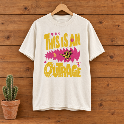 This Is An Outrage Comfort Colors shirt in Natural Ivory on a wooden hanger