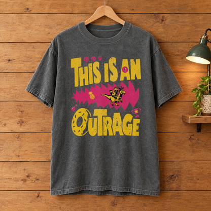This Is An Outrage Comfort Colors shirt in Pepper on a wooden hanger