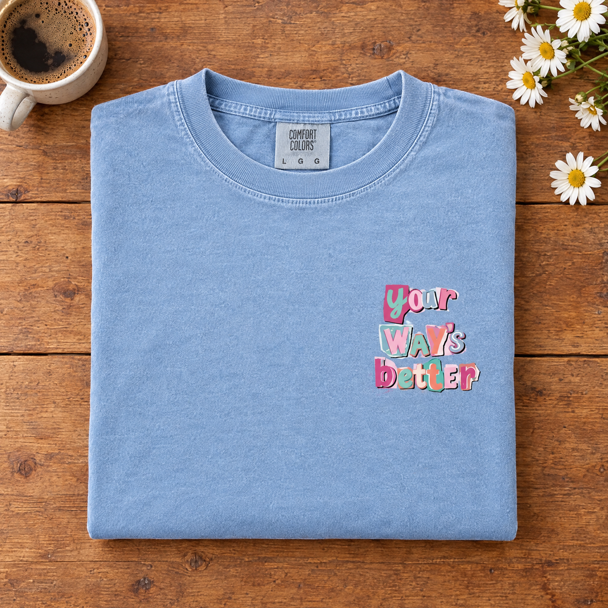 Your Way's Better faith tee in Chambray, folded with coffee and daisies