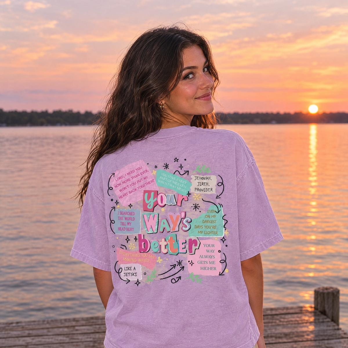 Woman in Orchid Comfort Colors Your Way's Better shirt showing the back print on a lake dock at sunset